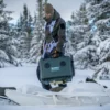En mann bærer en Euroheater ut av en pulk